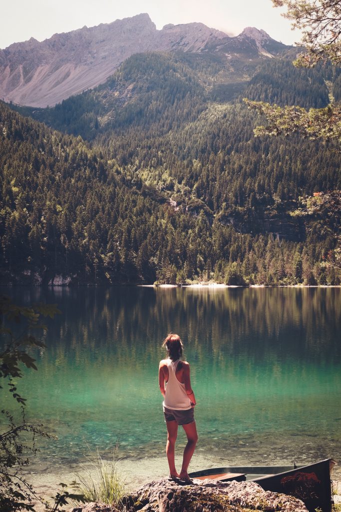 woman standing by mountain lake